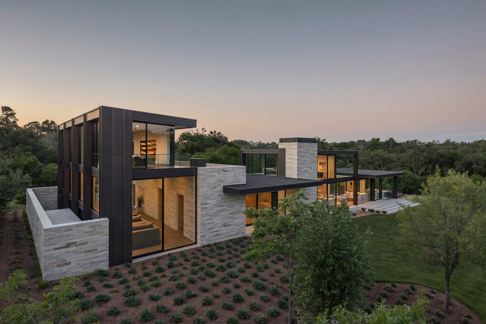 Completed modern limestone custom home at dusk in the Austin Hill Country