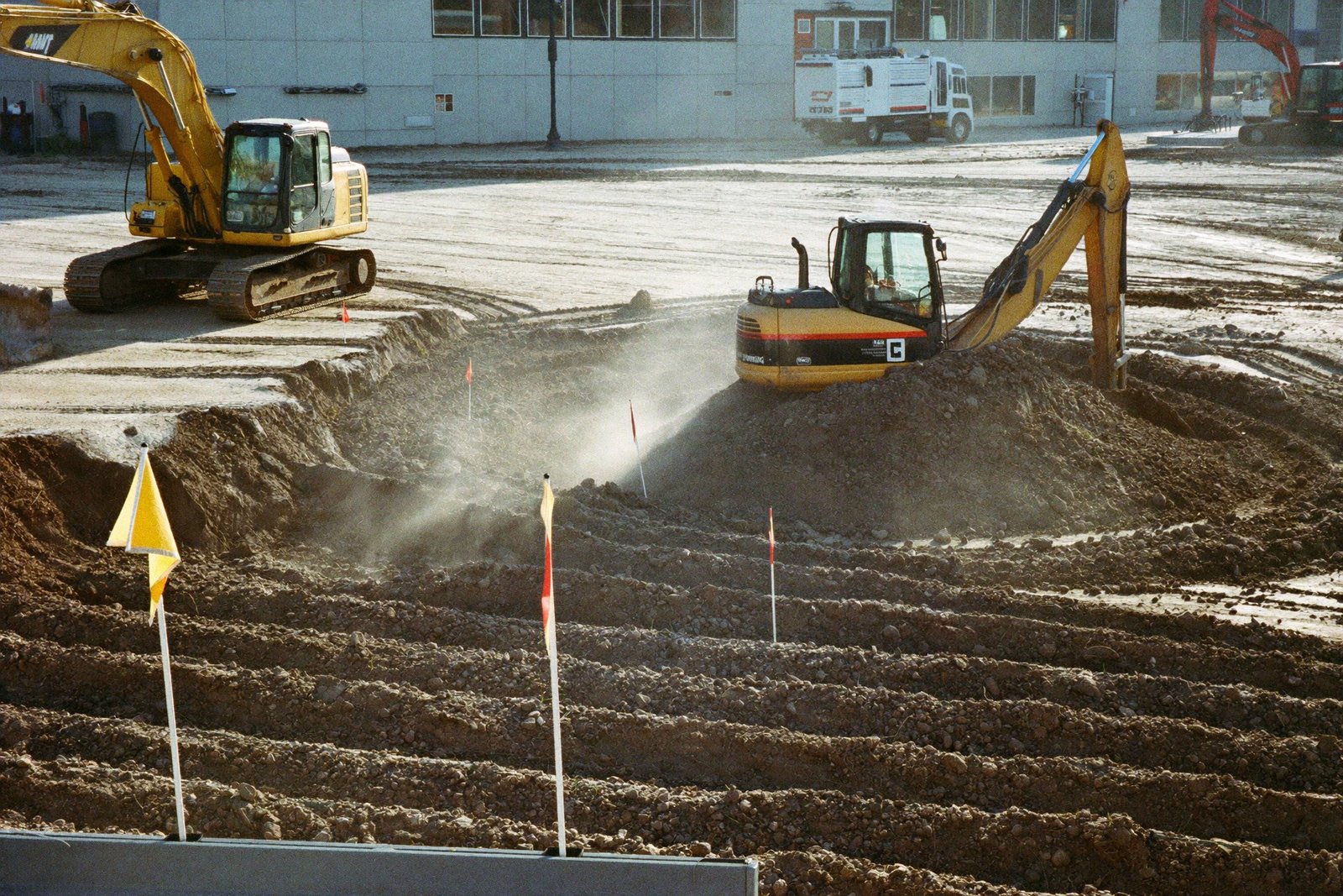 Excavators and graders preparing a commercial building pad in Houston
